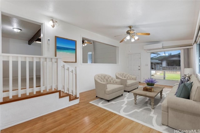 living room featuring a wall mounted air conditioner, hardwood / wood-style floors, and beamed ceiling