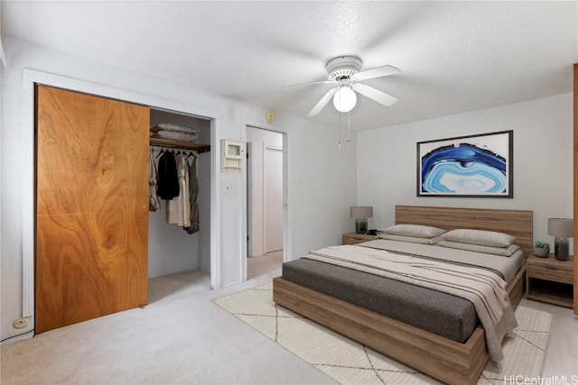 carpeted bedroom with ceiling fan, a textured ceiling, and a closet