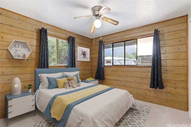 bedroom featuring ceiling fan, wooden walls, cooling unit, and light carpet