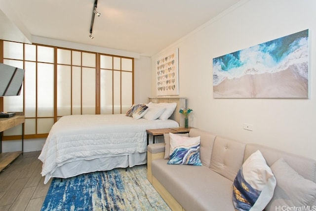 bedroom featuring crown molding and rail lighting