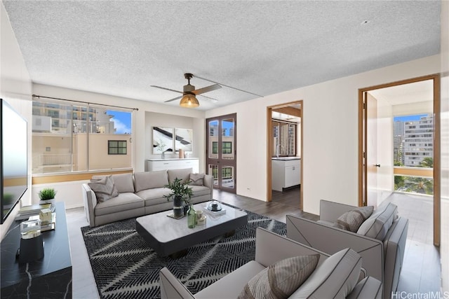 living room with a textured ceiling and ceiling fan