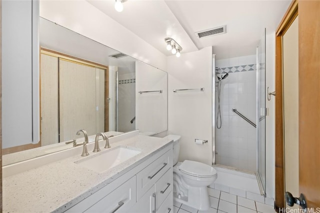 bathroom with toilet, a shower with door, vanity, and tile patterned flooring