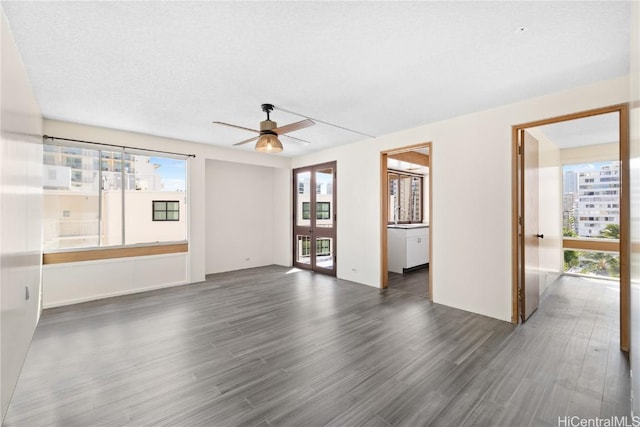 spare room featuring a textured ceiling, ceiling fan, and dark wood-type flooring