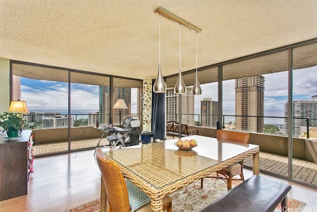 dining area with hardwood / wood-style flooring and a textured ceiling