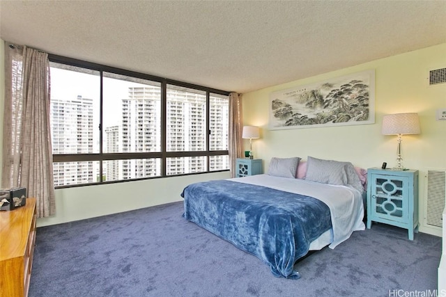 bedroom with dark carpet and a textured ceiling