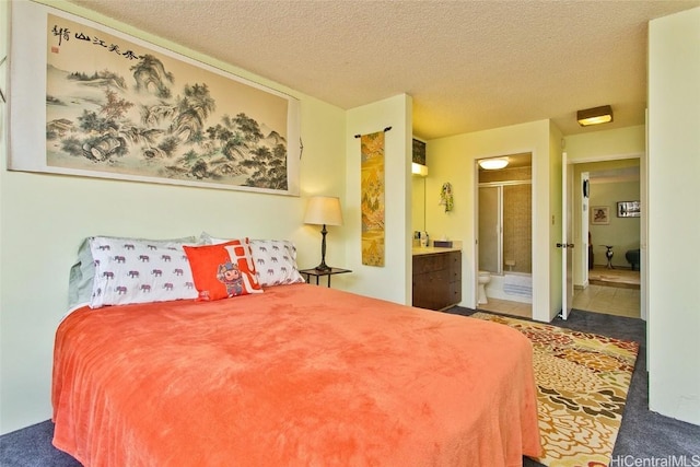 carpeted bedroom featuring a textured ceiling and ensuite bathroom