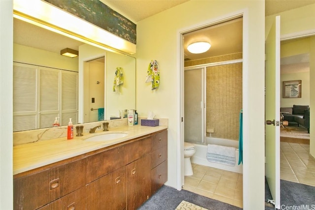 full bathroom featuring tile patterned flooring, vanity, toilet, and combined bath / shower with glass door