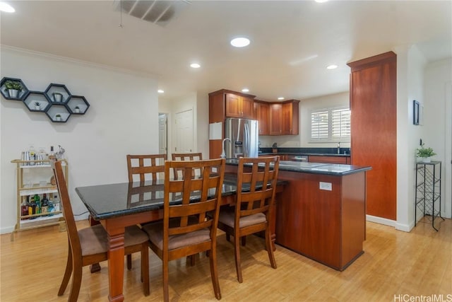 kitchen with ornamental molding, stainless steel fridge, light hardwood / wood-style floors, and sink