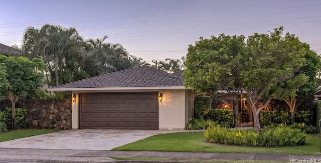 view of front facade featuring a garage and a yard