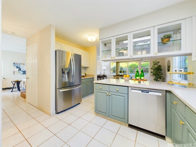 kitchen with light tile patterned floors, stainless steel appliances, and white cabinetry