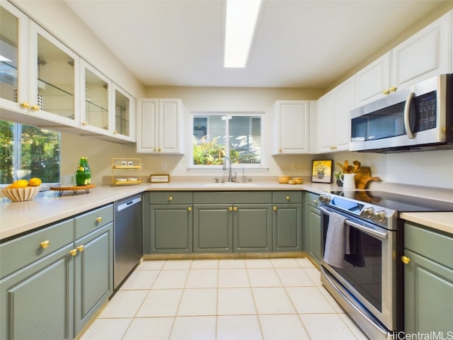 kitchen with white cabinetry, sink, light tile patterned floors, and appliances with stainless steel finishes