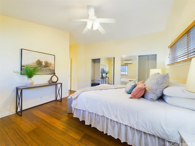 bedroom with an AC wall unit, multiple windows, ceiling fan, and dark wood-type flooring