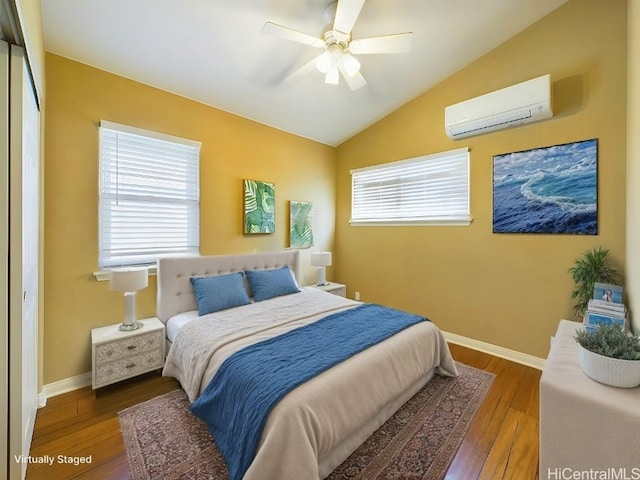 bedroom featuring dark hardwood / wood-style flooring, a wall mounted AC, lofted ceiling, and ceiling fan