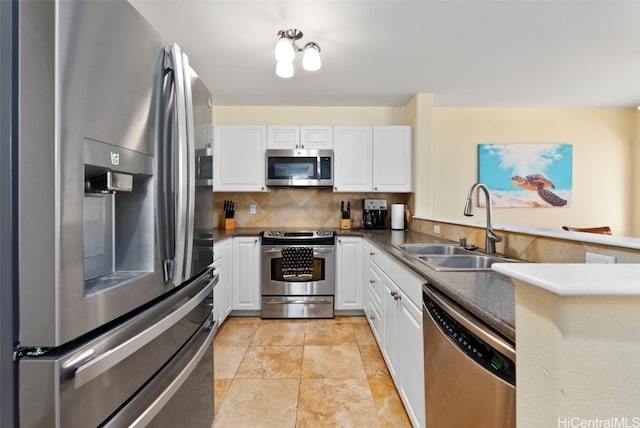 kitchen with white cabinets, appliances with stainless steel finishes, tasteful backsplash, and sink