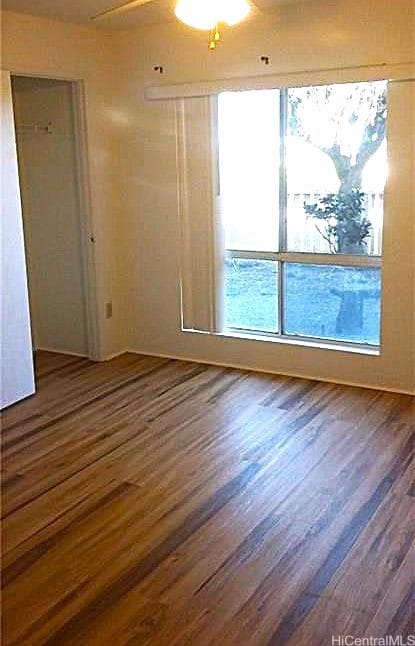 empty room with dark hardwood / wood-style floors and ceiling fan