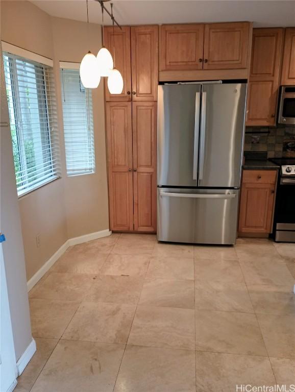 kitchen with tasteful backsplash, light tile patterned flooring, appliances with stainless steel finishes, and pendant lighting