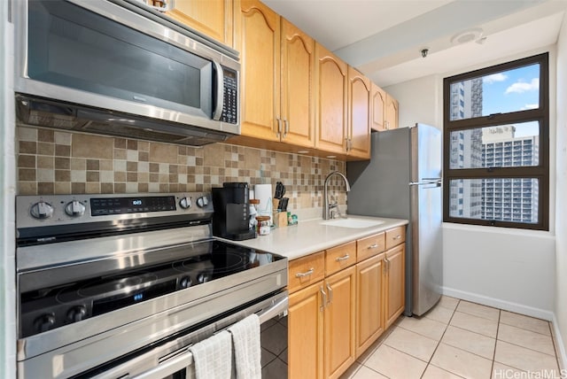 kitchen with sink, stainless steel appliances, light tile patterned flooring, and backsplash