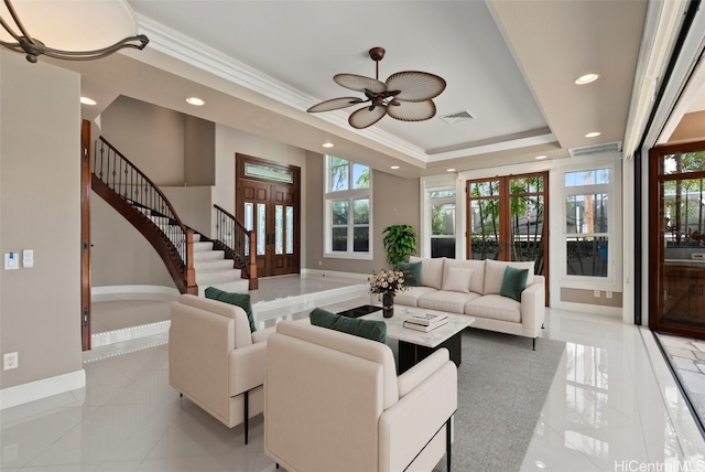 living room with ceiling fan, french doors, light tile patterned flooring, and a tray ceiling