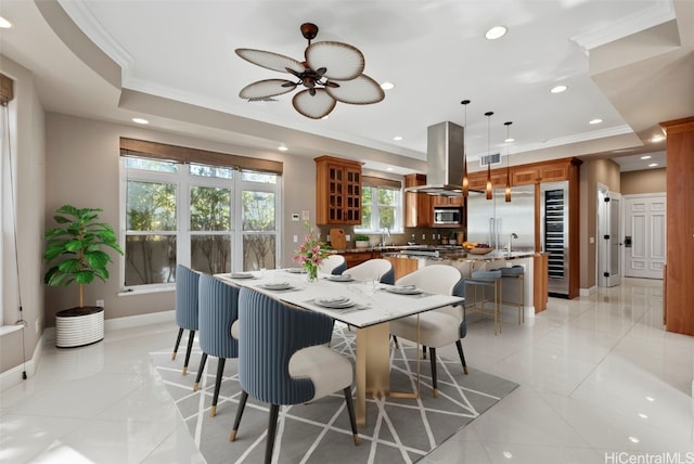 dining space with ceiling fan, light tile patterned floors, sink, and crown molding