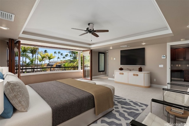 bedroom with a raised ceiling, ceiling fan, light carpet, and multiple windows