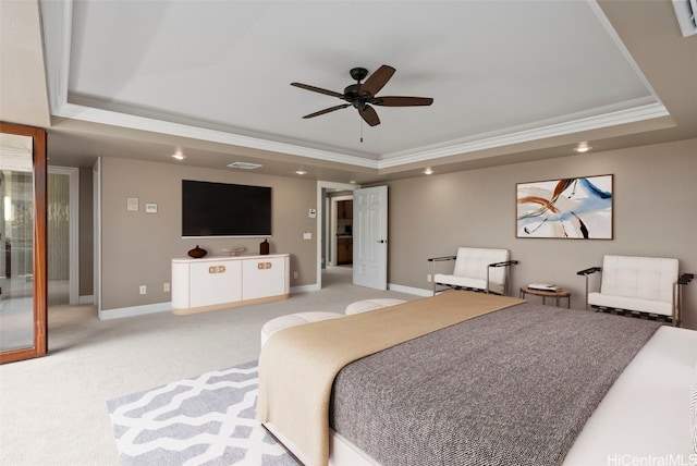 carpeted bedroom featuring ceiling fan, ornamental molding, and a tray ceiling