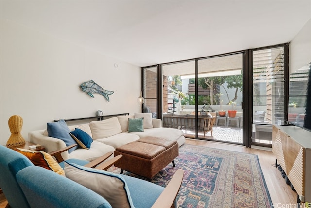 living room featuring light hardwood / wood-style flooring and a wall of windows