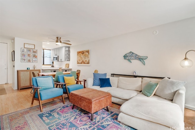 living room with ceiling fan and light wood-type flooring