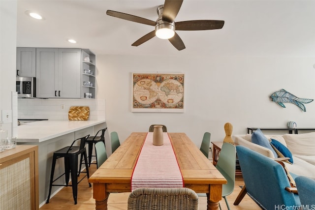 dining area with ceiling fan and light wood-type flooring