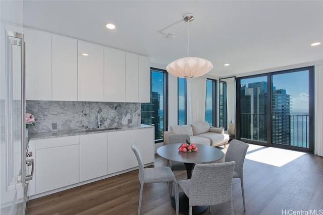 dining space with sink, dark wood-type flooring, expansive windows, and plenty of natural light