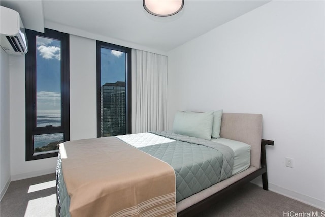 bedroom with an AC wall unit and dark carpet