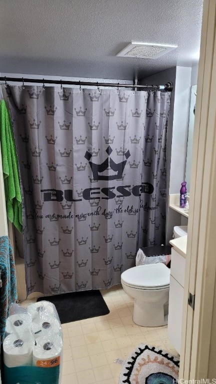 bathroom featuring vanity, a textured ceiling, toilet, and walk in shower