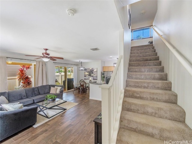 stairway with hardwood / wood-style flooring and ceiling fan