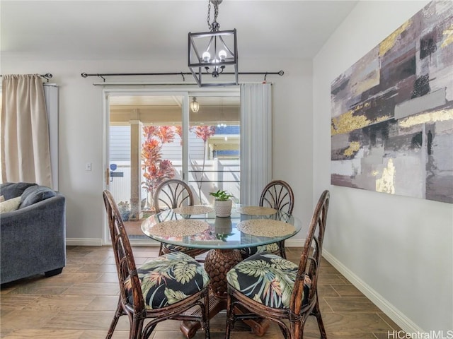 dining space featuring wood-type flooring and an inviting chandelier