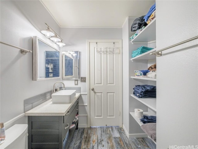 bathroom with ornamental molding, vanity, toilet, and wood-type flooring