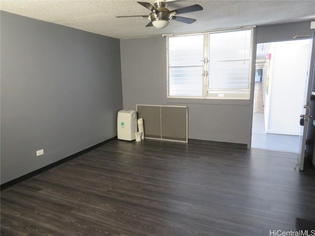 empty room with ceiling fan, dark hardwood / wood-style floors, and a textured ceiling