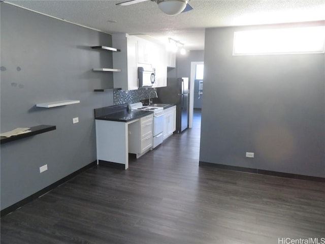 kitchen featuring decorative backsplash, stainless steel fridge, dark wood-type flooring, white cabinets, and white stove