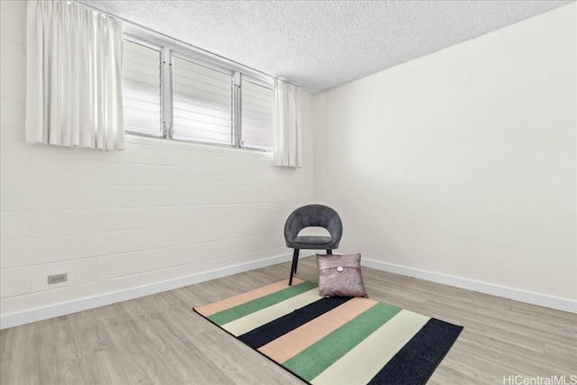 unfurnished room with a textured ceiling and hardwood / wood-style floors