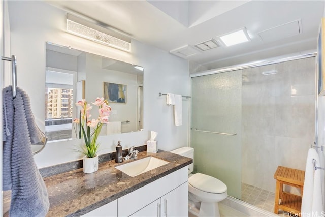 bathroom with a shower with shower door, vanity, and toilet