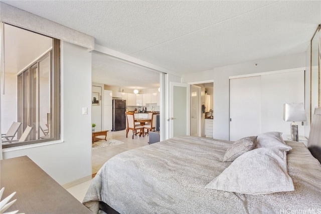 bedroom featuring a textured ceiling and black fridge