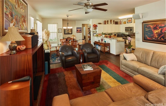 living room with dark hardwood / wood-style floors and ceiling fan with notable chandelier