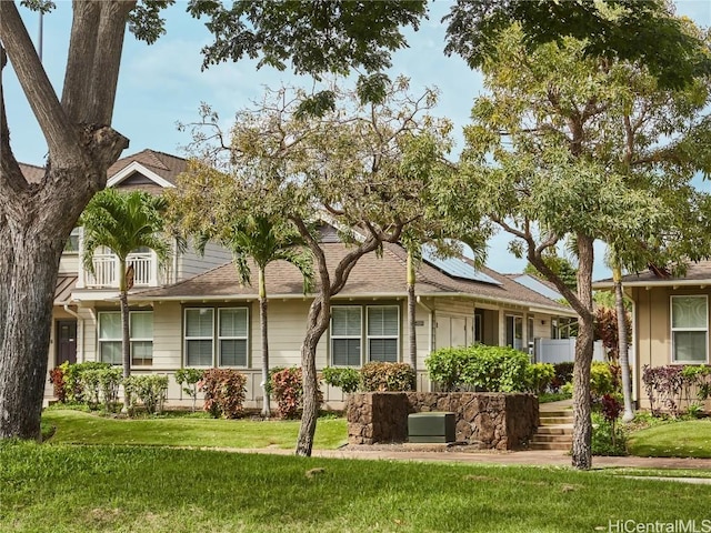 view of front of property featuring a front yard and solar panels