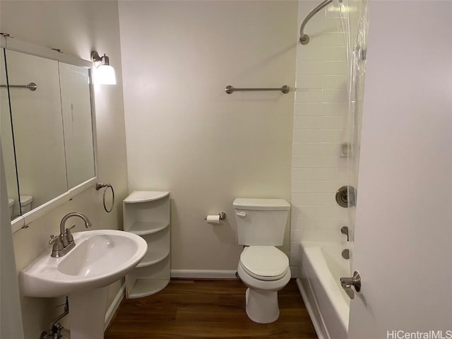 full bathroom featuring sink, hardwood / wood-style flooring, tiled shower / bath combo, and toilet