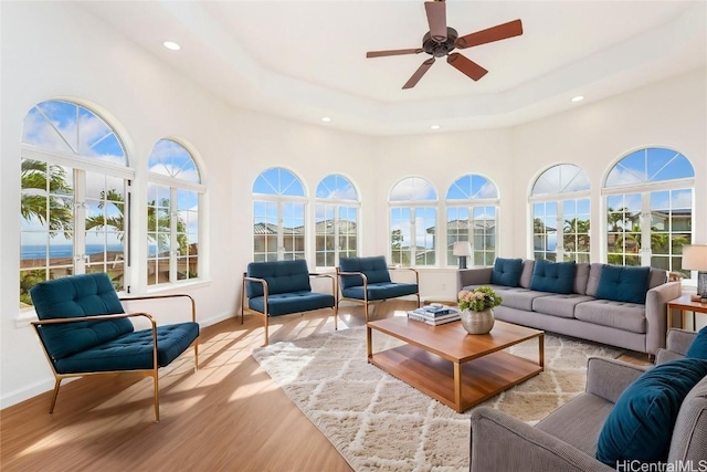 sunroom with ceiling fan and a raised ceiling