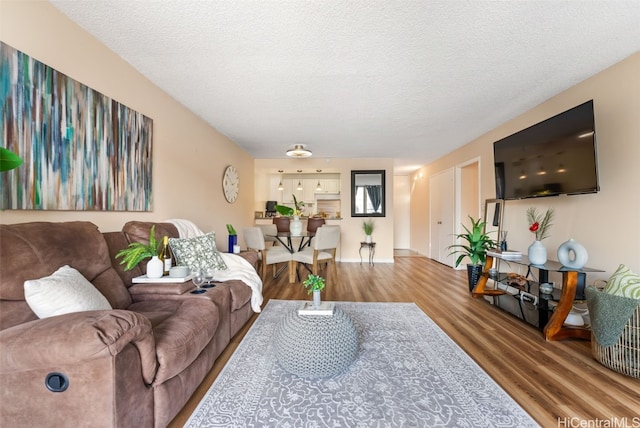 living room with wood-type flooring and a textured ceiling