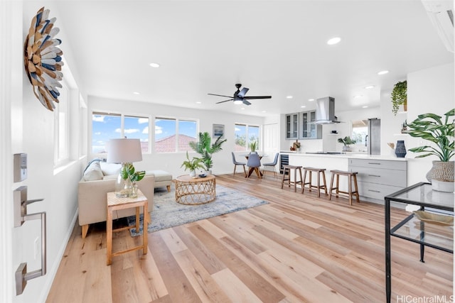 living room featuring ceiling fan, light hardwood / wood-style flooring, and plenty of natural light