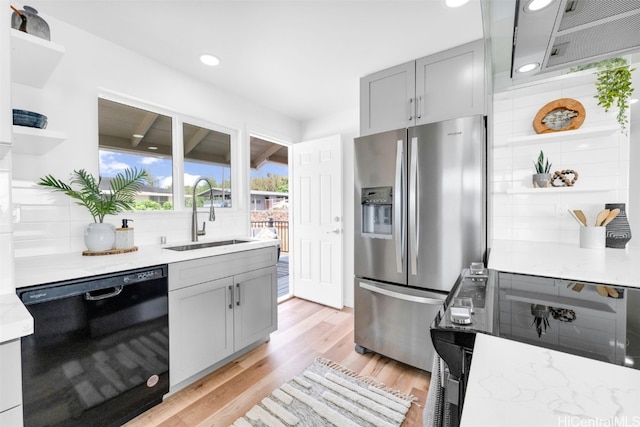 kitchen with stainless steel refrigerator with ice dispenser, decorative backsplash, gray cabinets, black dishwasher, and sink