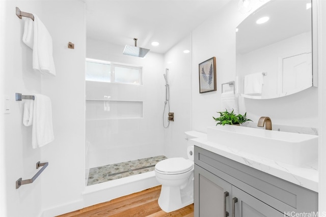 bathroom featuring toilet, hardwood / wood-style floors, walk in shower, and vanity