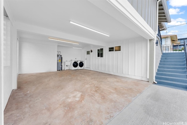 garage with washer and clothes dryer and electric water heater