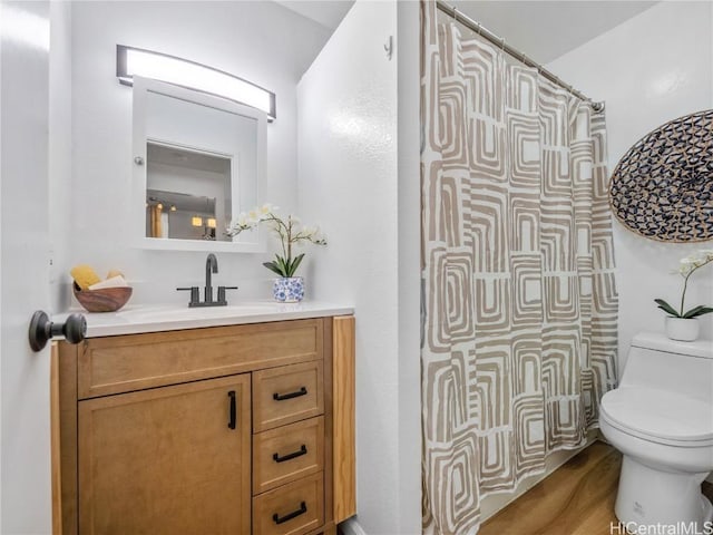 bathroom featuring vanity, hardwood / wood-style flooring, toilet, and curtained shower