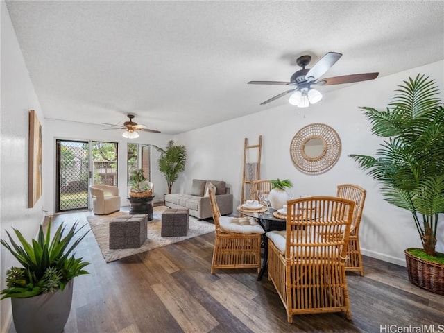 living room with a textured ceiling, ceiling fan, and dark wood-type flooring